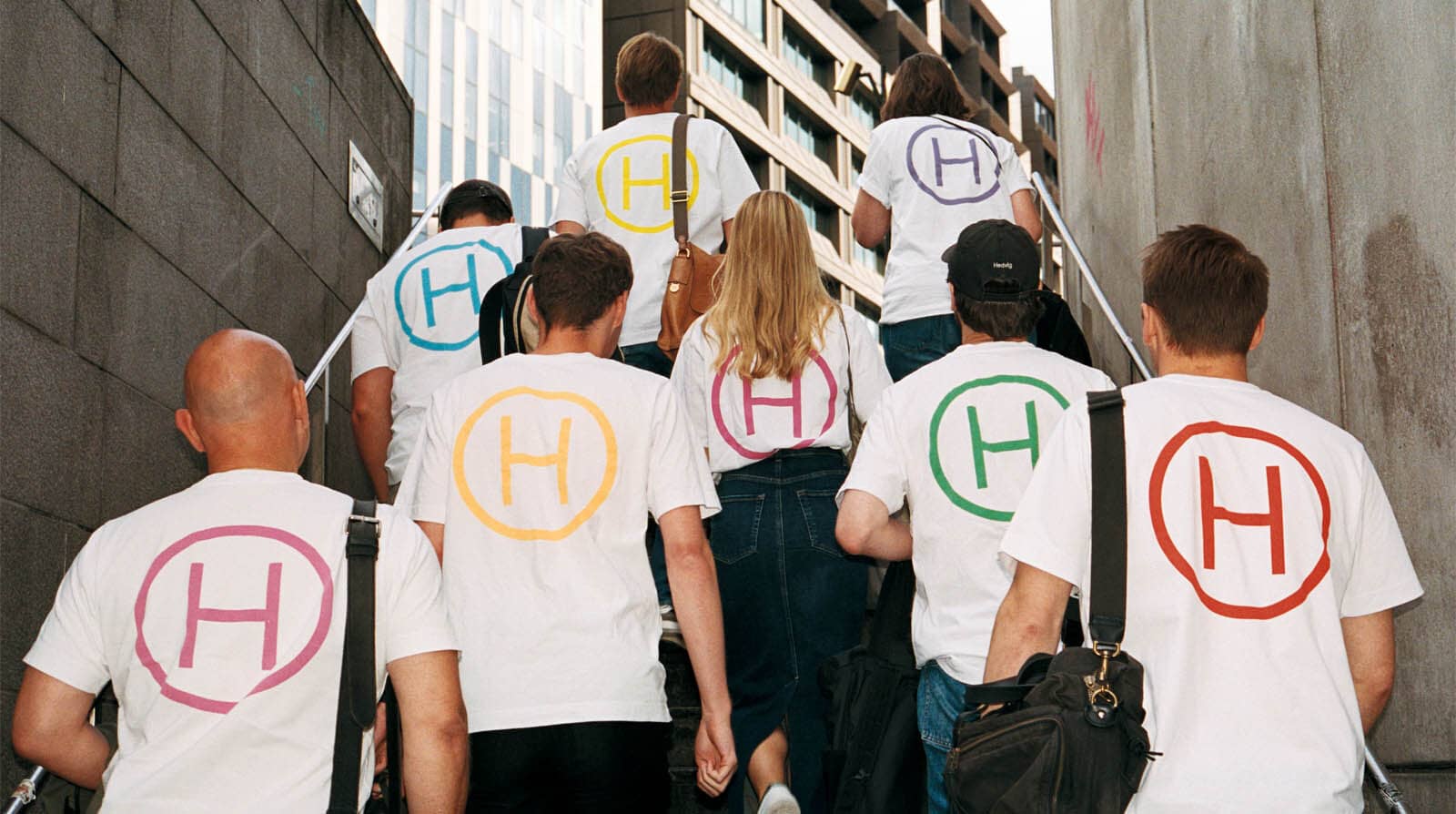 Employees in Hedvig t-shirts go up a flight of stairs